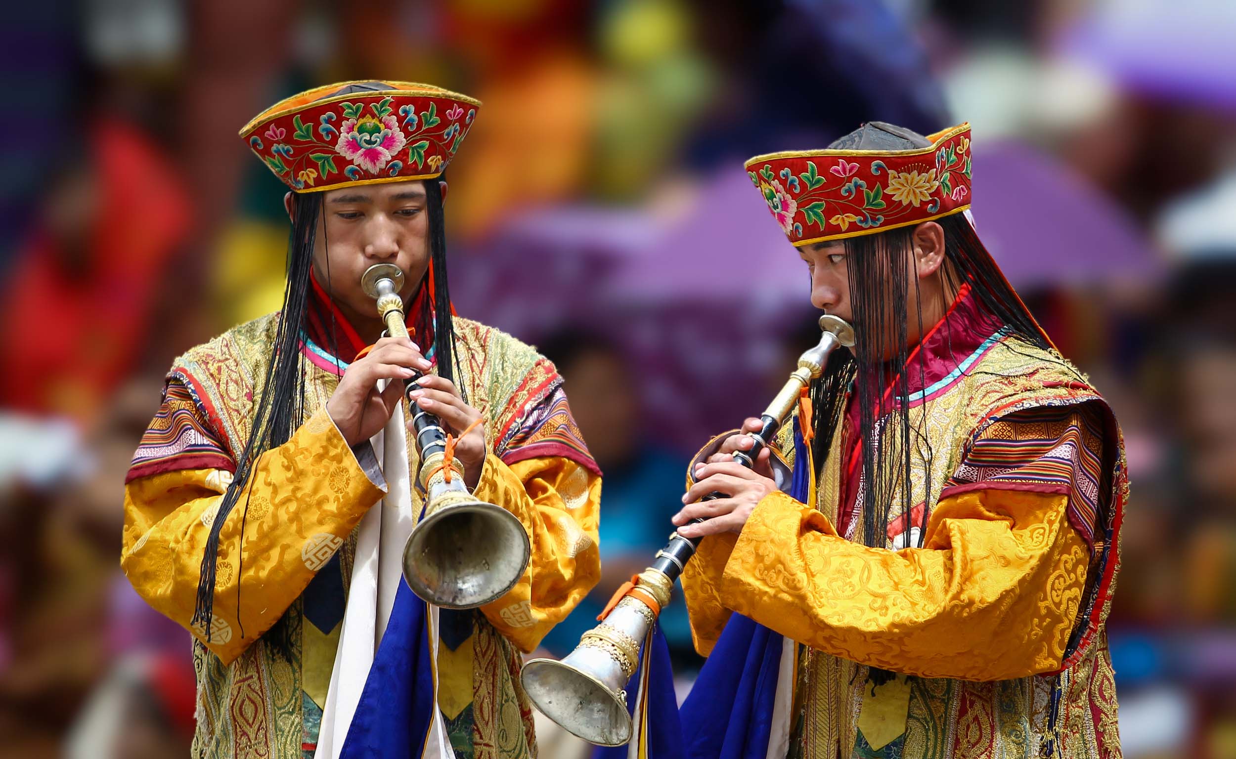 Two festival musicians playing ceremonial horns