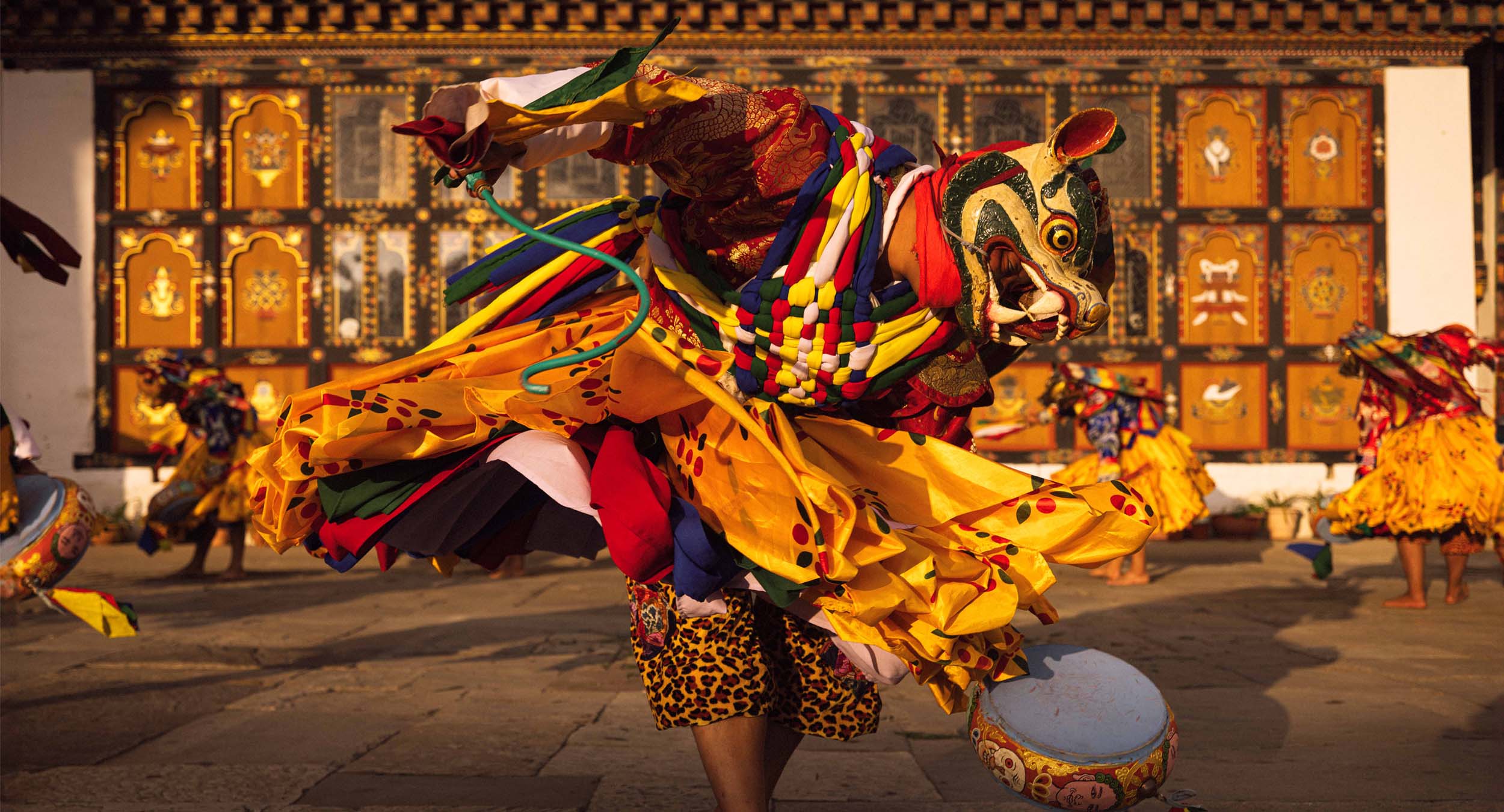 A masked dancer twirling at a Bhutanese tsechu festival