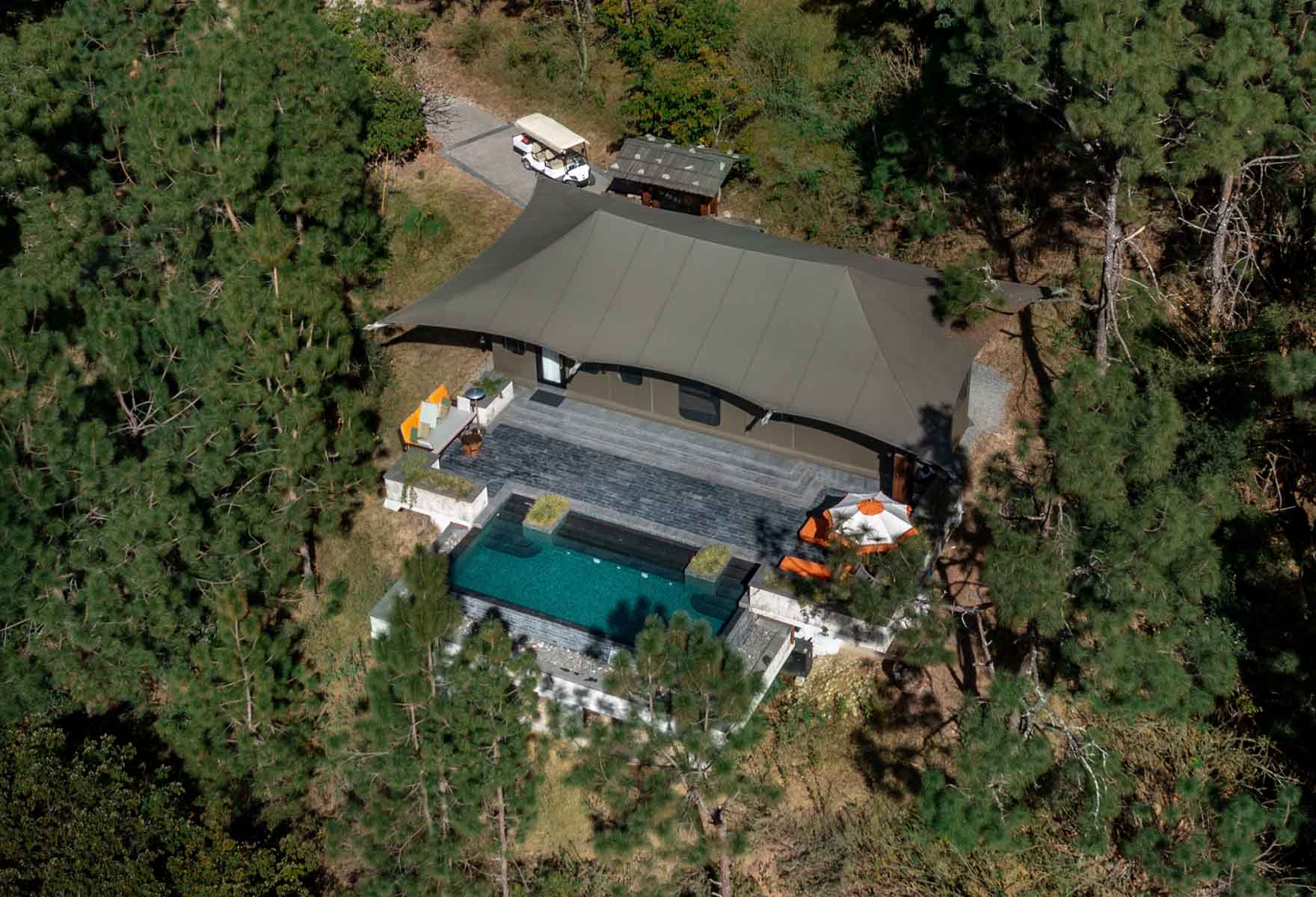 Aerial view of a luxury Bhutanese lodge with a pool set in forest