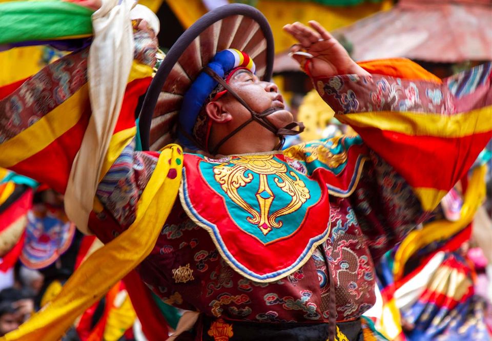 Dancer in a black hooped headdress spinning at Thimphu Tshechu
