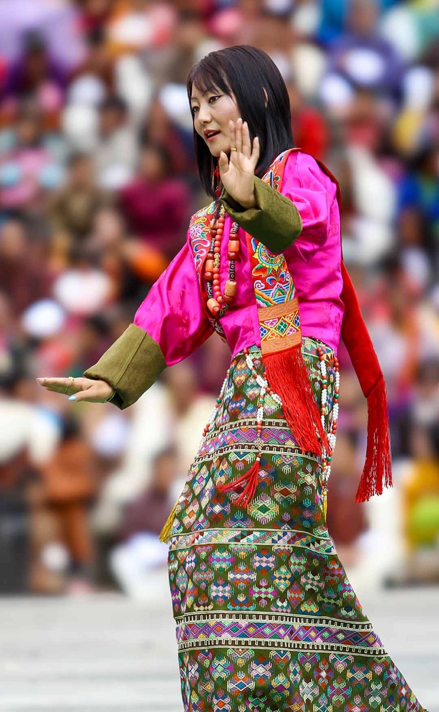 Woman in a traditional kira and pink tego at a festival ground