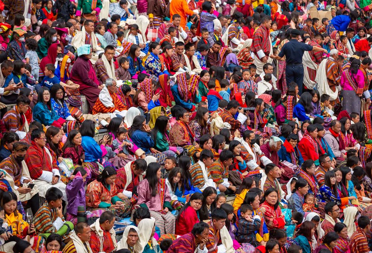 A packed festival crowd in colourful traditional dress