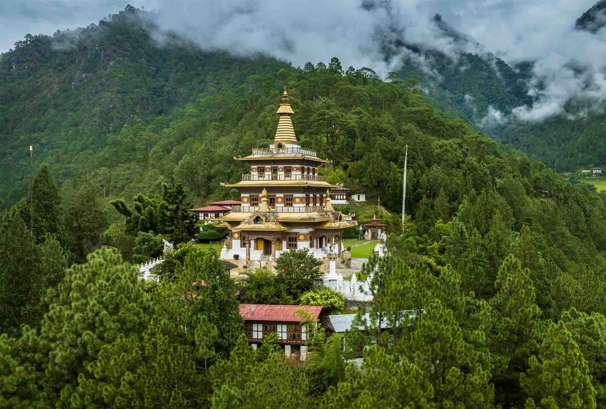 A golden-roofed temple on a forested hillside in Bhutan