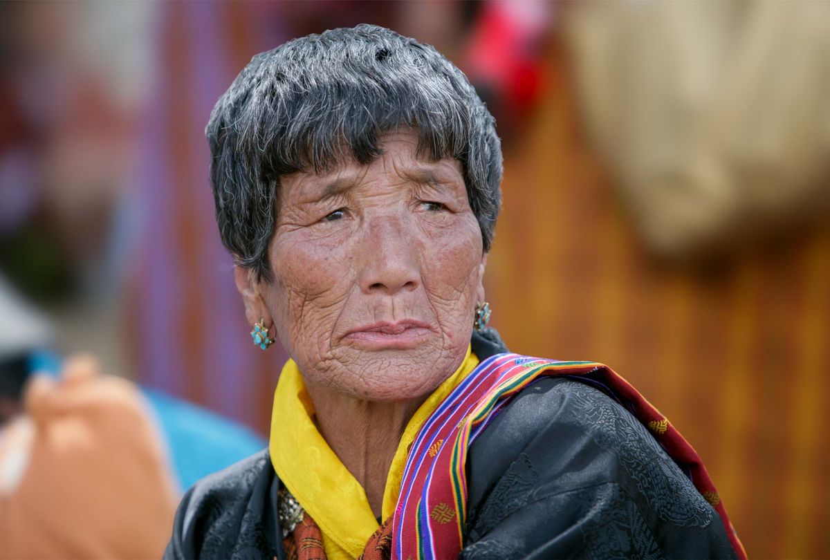 An elderly Bhutanese woman in traditional dress and jewellery