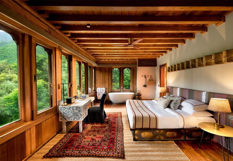 A timber-lined suite with a freestanding bath and valley view