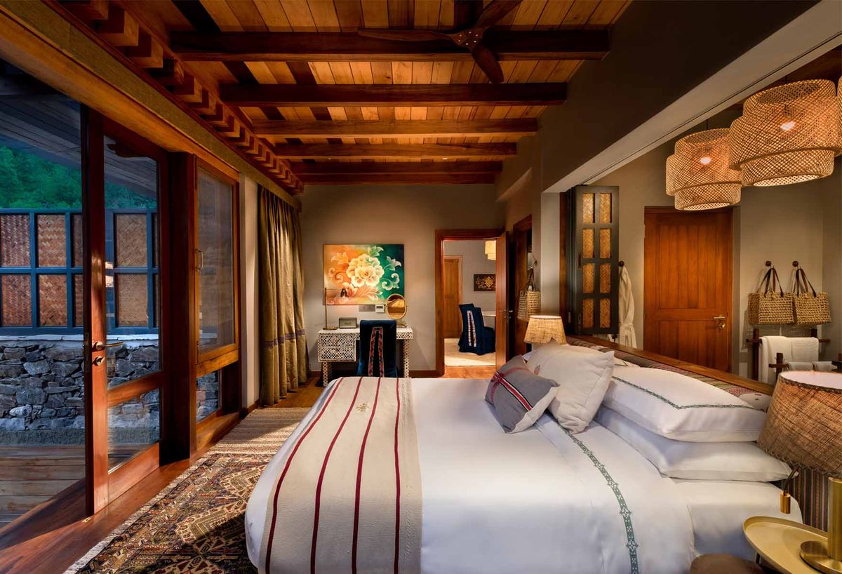 A timber-panelled hotel suite with a made bed and valley outlook
