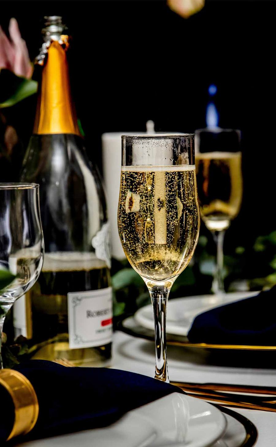 Champagne poured into a flute beside a chilled bottle