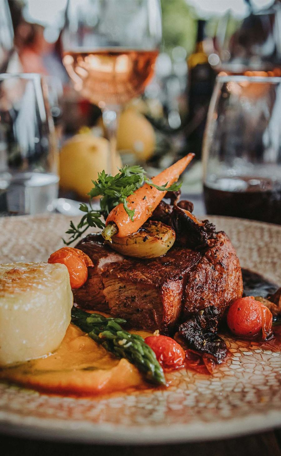 A plated fine-dining main course on a linen-set table