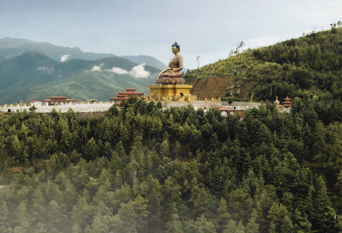 The Buddha Dordenma statue above forested hills near Thimphu