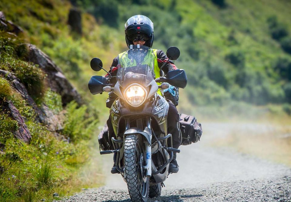 A rider on a country road lined with autumn foliage