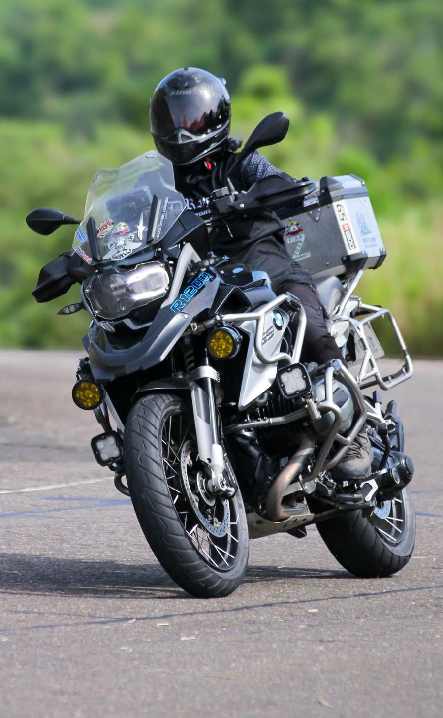 A rider leaning an adventure motorcycle through a highway bend