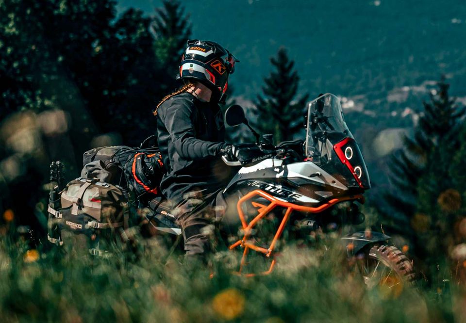 Two riders on adventure bikes on a forested mountain road