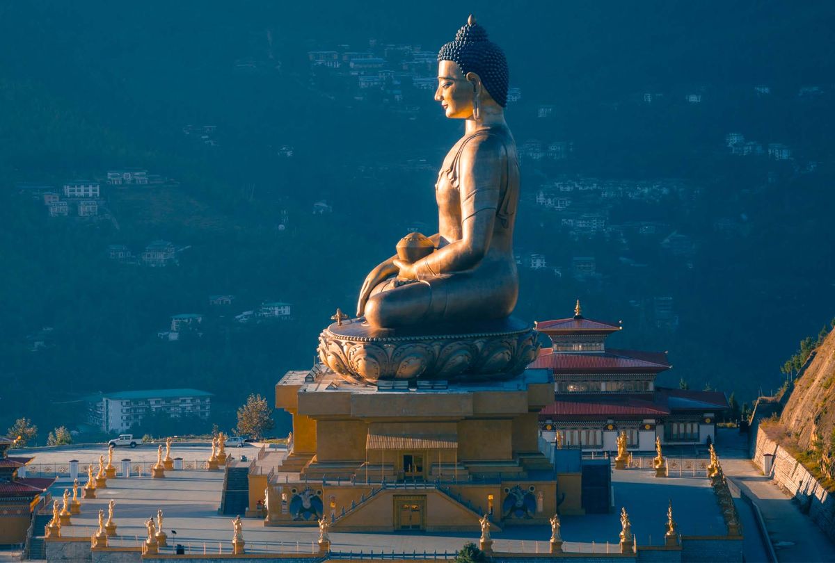 The Buddha Dordenma statue lit at dusk above Thimphu