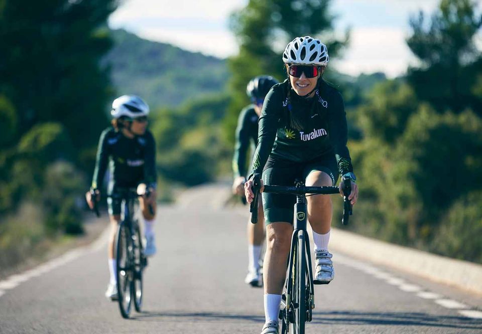 Cyclists riding away along a centre-lined mountain road