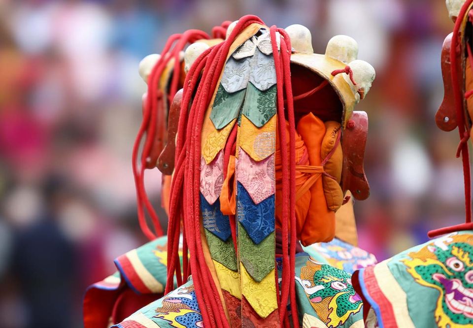 Brocade festival costume and layered silk collar at a Bhutanese tsechu