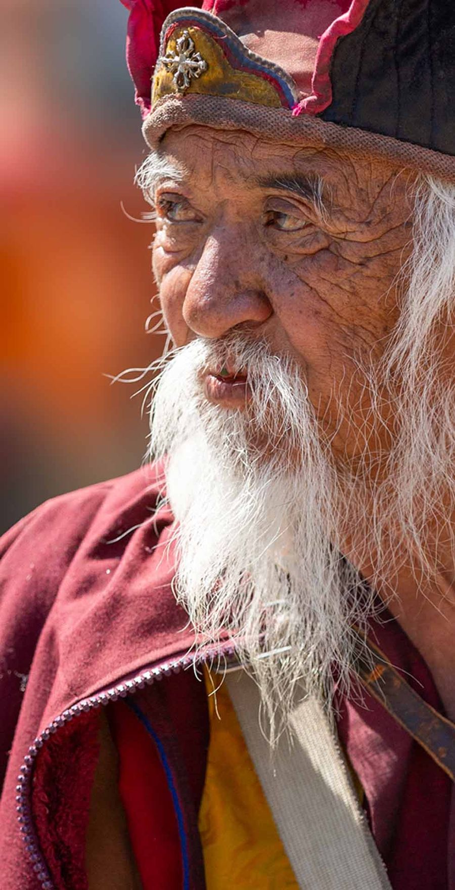 Bhutanese elder with a white beard in a ceremonial hat and robe