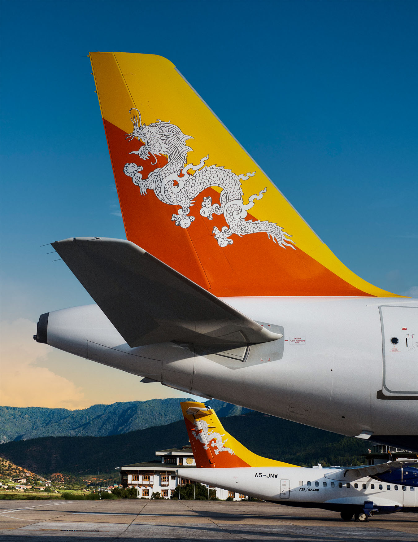 A Drukair aircraft with the Bhutanese dragon on its tail, in flight and on the apron at Paro airport