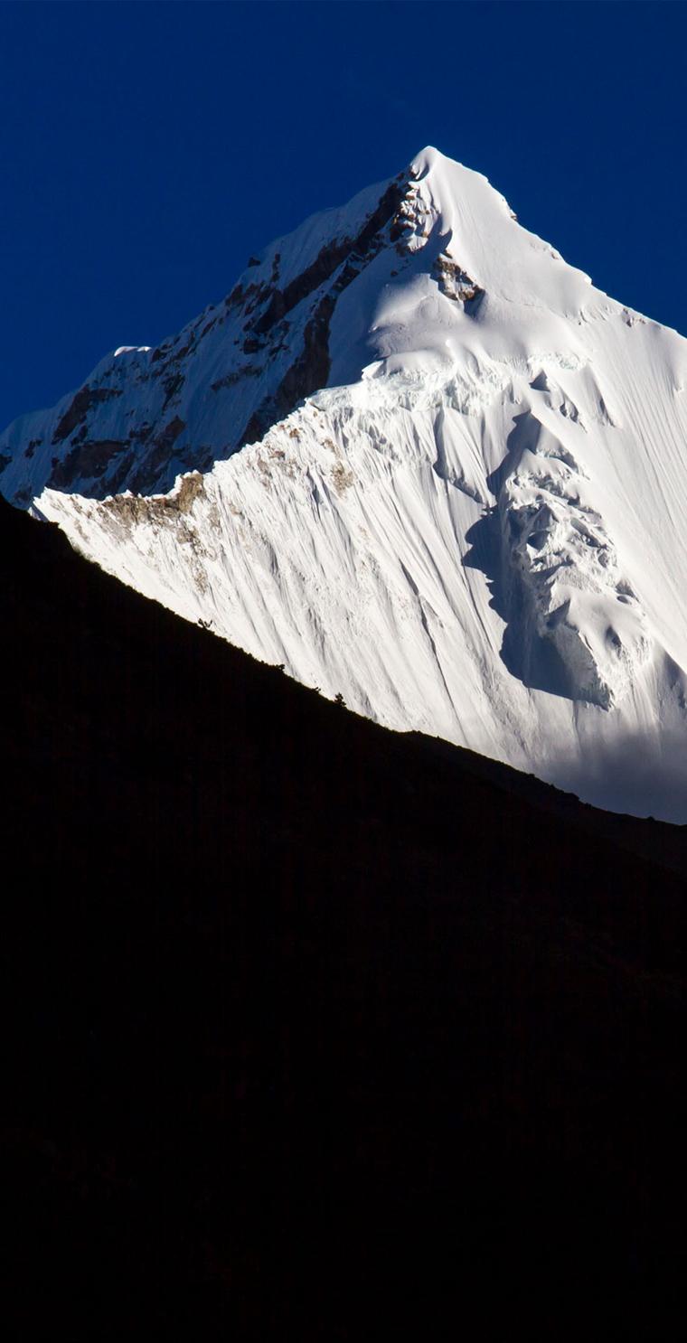The snow-clad summit of Jomolhari against a deep blue sky