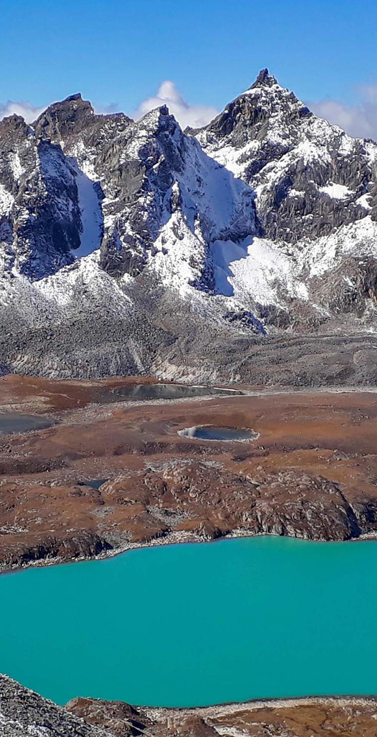 Jagged snow-covered peaks above a turquoise glacial lake